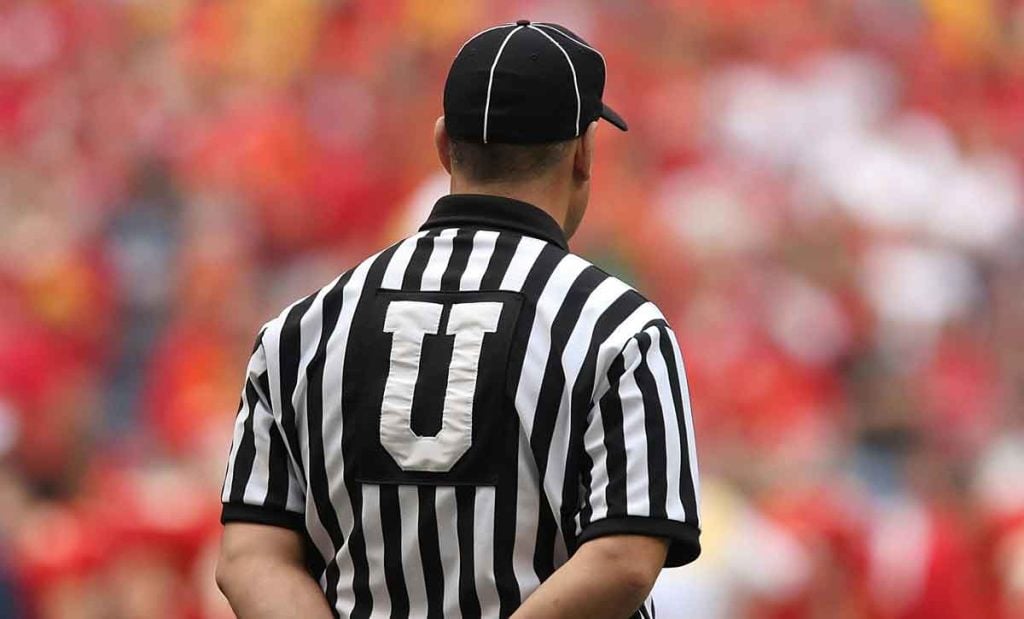 Marketing clichés boost the U in your Unique Selling Proposition. Image depicts an umpire, with back and white striped shirt and a large U on the back.